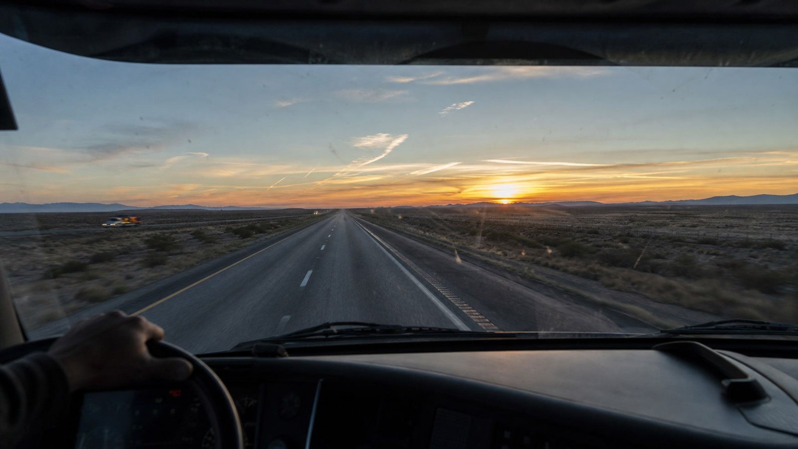 Open interstate highway at dawn seen from a truck cab