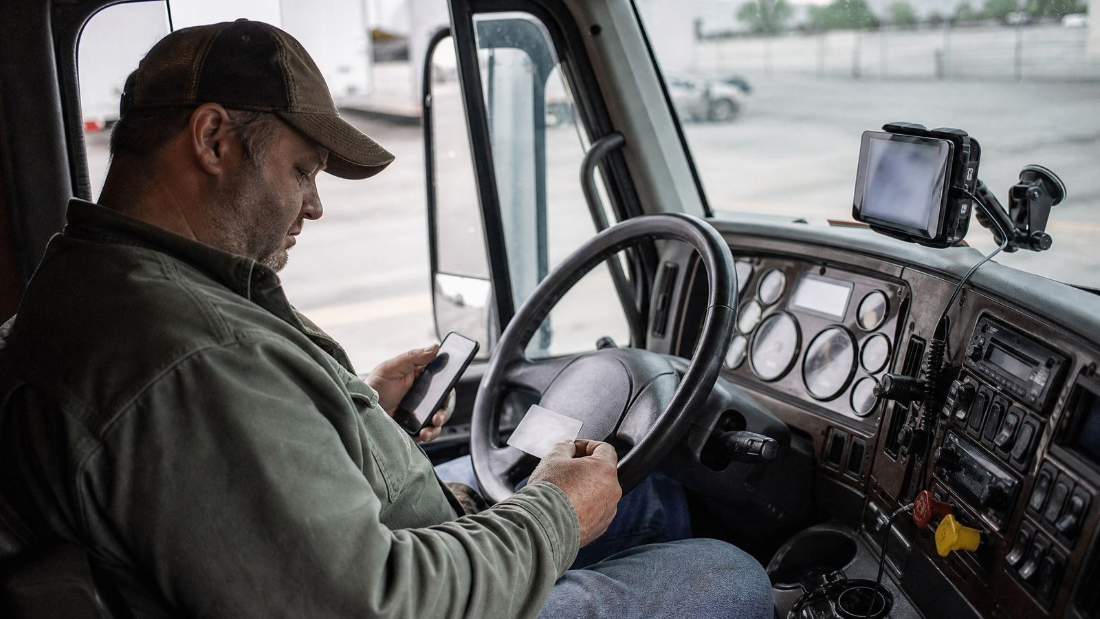 Phone, fuel card and logging device on the dashboard of a semi truck
